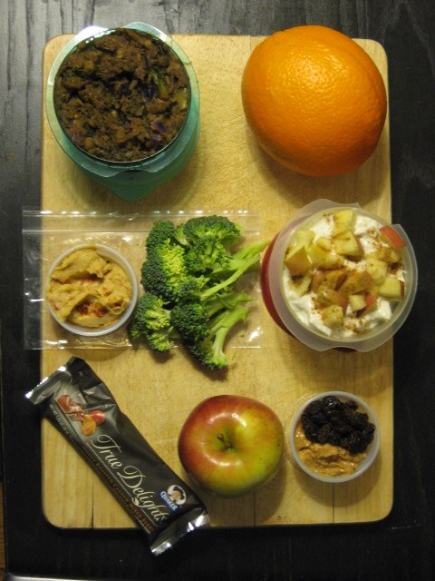giant orange for mid-morning snack, date + kale curry for lunch, greek yogurt with apples/bananas/cinnamon/ginger for lunch dessert, broccoli trees with roasted red pepper hummus for afternoon snack, apple with a tbsp each of pb and raisins for evening snack/dinner in class, Quaker True Delights bar for evening snack/dinner dessert in class